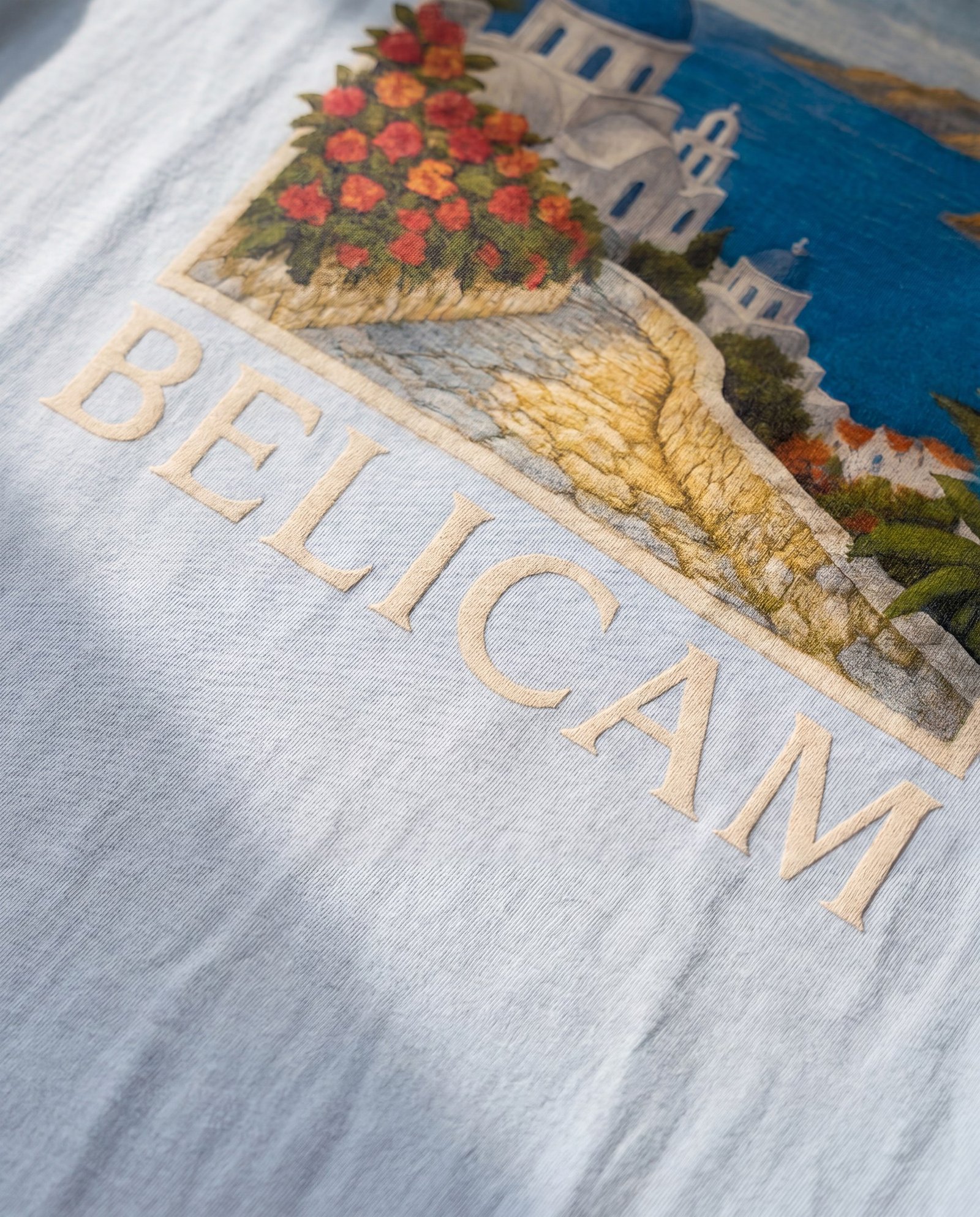 Détail BELICAM — artwork méditerranéen au dos du t-shirt bleu clair